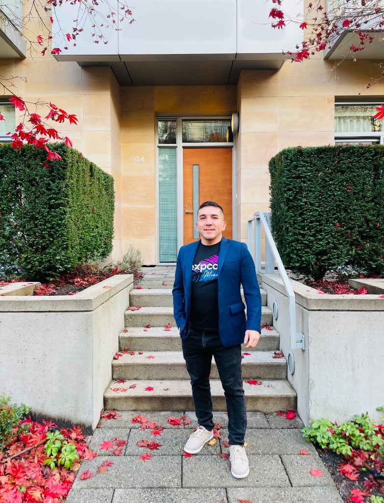 Adam Naamani outdoors in front of a building entrance.